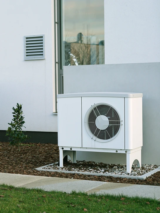 Un technicien travaillant sur la climatisation ou la pompe à chaleur d'une unité extérieure