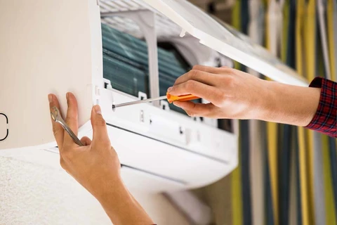 Intérieur résidentiel, technicien installe ou répare une unité de climatisation murale split