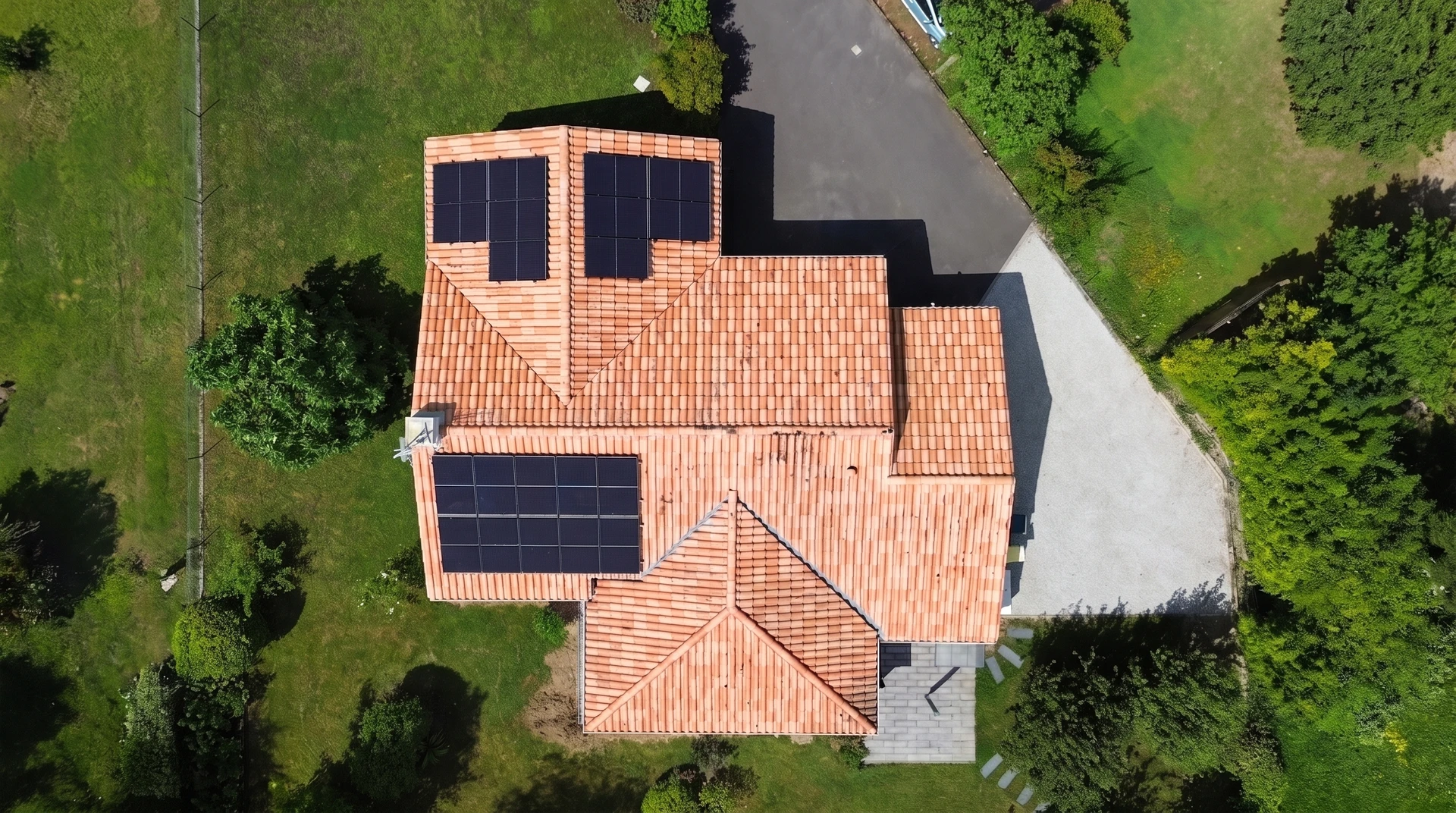 Toiture résidentielle équipée de panneaux solaires photovoltaïques installés sur tuiles en terre cuite ondulées