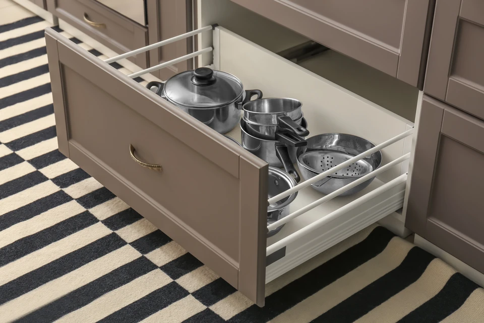Vue d'une cuisine moderne et lumineuse entièrement rénovée, montrant l'espace ouvert bien organisé avec plan de travail optimisé, électroménagers intégrés et rangements intelligents. La photo doit capturer l'atmosphère confortable et fonctionnelle du quotidien, avec un éclairage naturel mettant en valeur la qualité de la réalisation et l'optimisation de l'espace de vie.