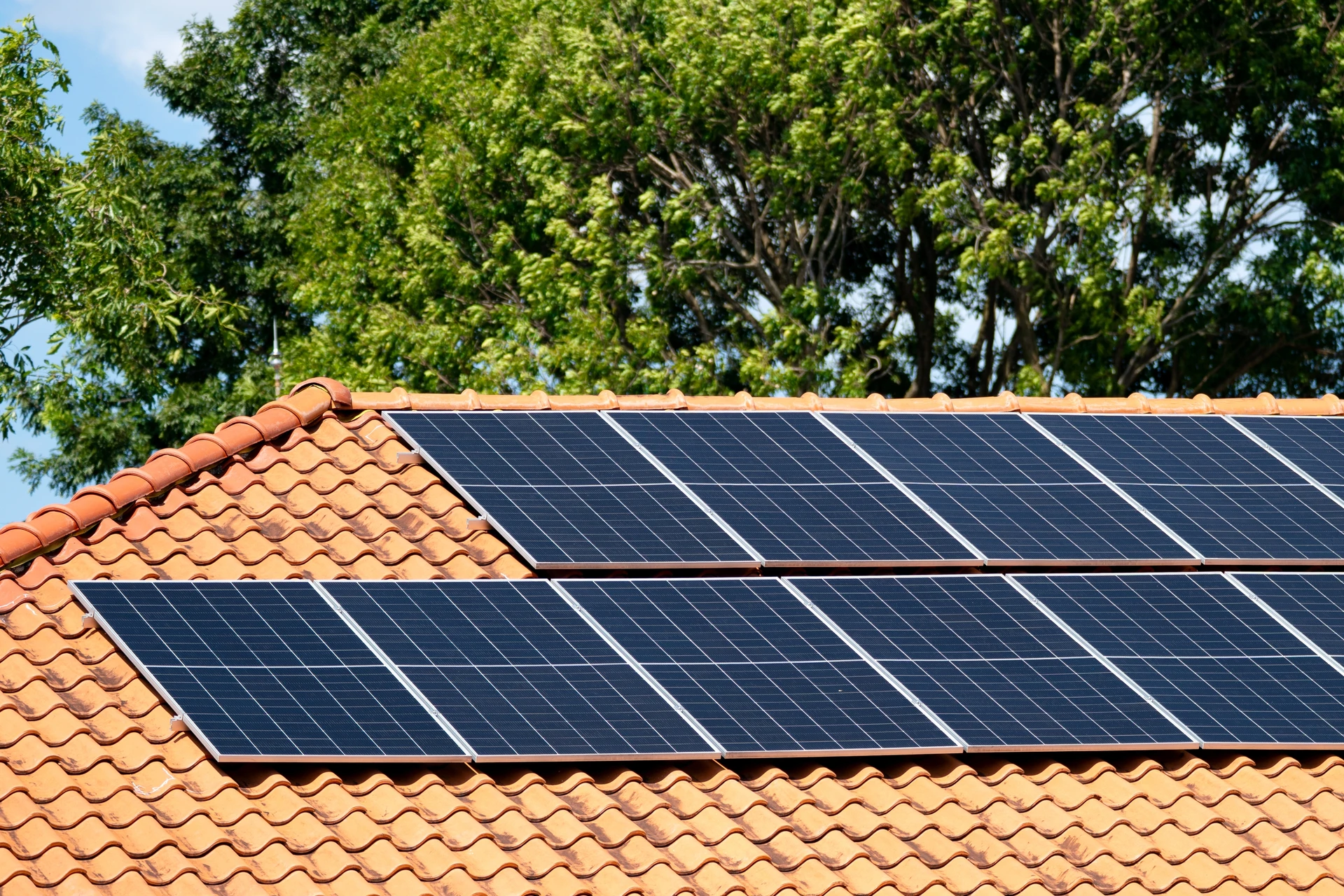 Ouvrier installateur en équipement de protection sur toiture de bâtiment résidentiel, travaillant sur structure métallique de support