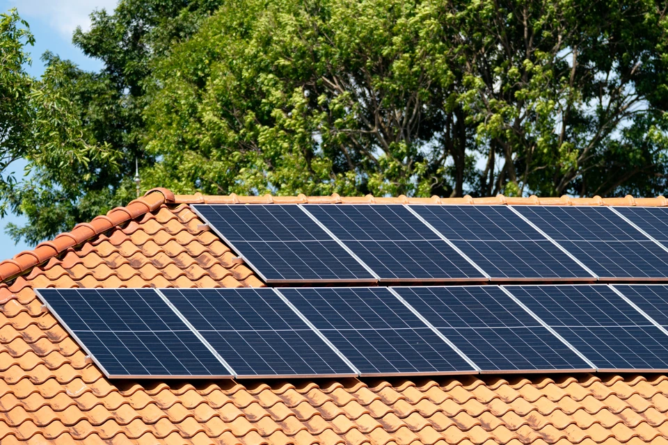 Toiture résidentielle équipée de panneaux solaires photovoltaïques installés sur tuiles en terre cuite ondulées